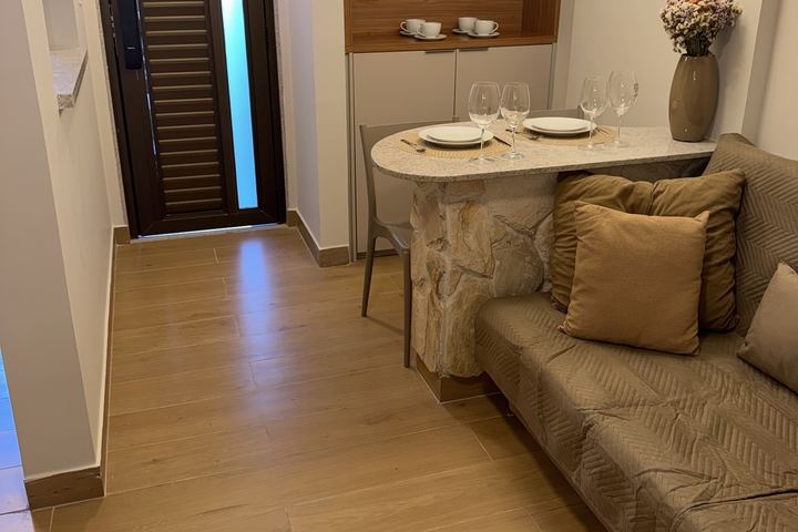 Sala vista da entrada, com mesa de pedra e sofá-cama