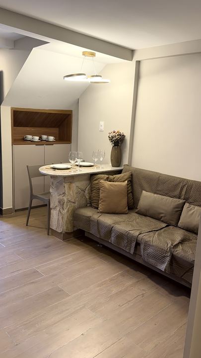 Sala em foto vertical, com nicho de madeira e sofá-cama