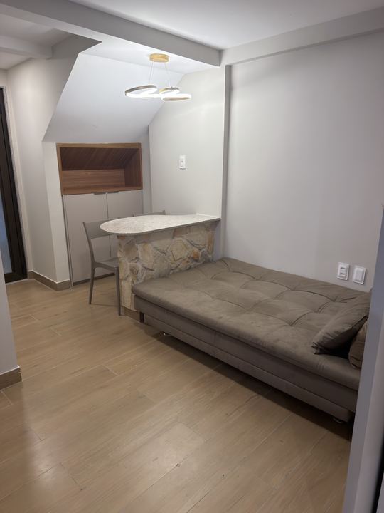 Sofá-cama visto de frente, com a mesa de jantar ao fundo