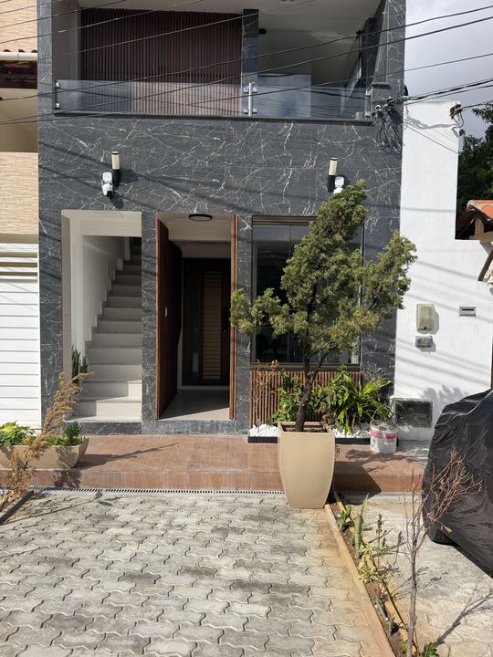 Fachada de dia com vaso e calçada de pedras