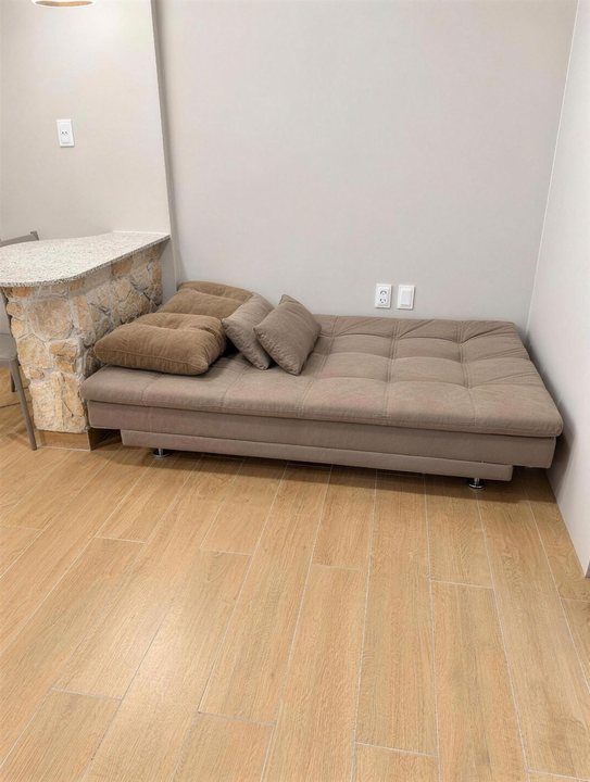 Sofá-cama aberto como chaise, sobre piso amadeirado