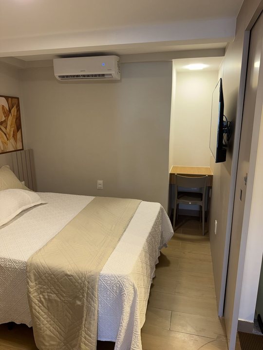 Quarto com cama de casal, ar-condicionado e escrivaninha