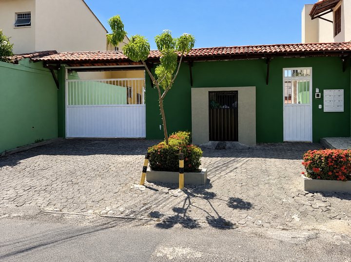 Rua calçada com casa de portão verde ao fundo